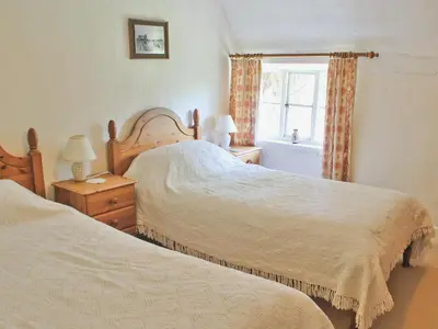 a bedroom with two beds and a window at The Old House in Mellis