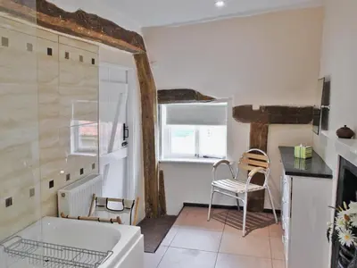 a bathroom with a tub and a table and chairs at The Old House in Mellis