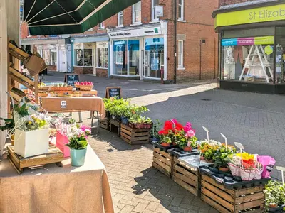 a street with tables with potted plants on it at Stable End in Halesworth