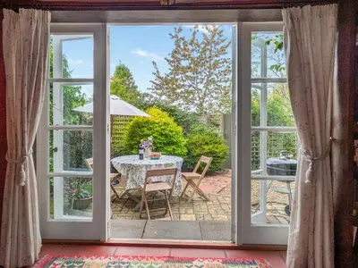 an open door to a patio with a table at Stable End in Halesworth