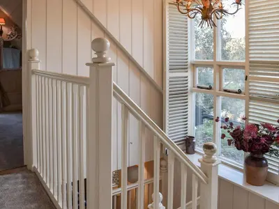 a staircase in a house with a chandelier at Swallows Nest in Saint Lawrence