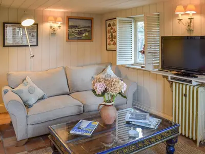 a living room with a couch and a tv at Swallows Nest in Saint Lawrence