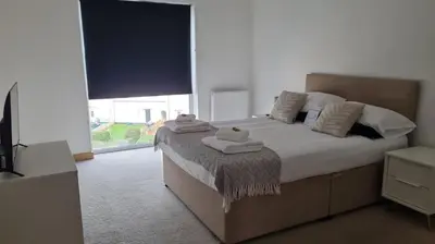 a bedroom with a large bed with towels on it at Modern 2 bed flat with balcony in Southend-on-Sea