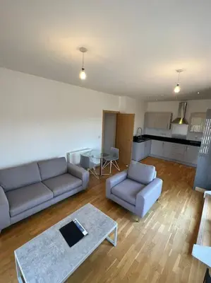 a living room with two couches and a kitchen at Modern 2 bed flat with balcony in Southend-on-Sea