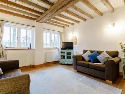 a living room with two couches and a tv at Wheelwrights Cottage in Rumburgh