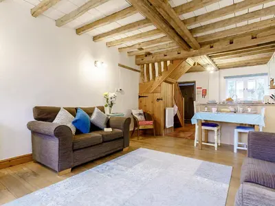 a living room with a couch and a table at Wheelwrights Cottage in Rumburgh