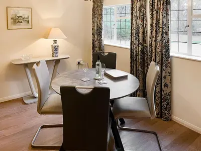 a dining room with a table and chairs and a window at The Cottage in Fressingfield