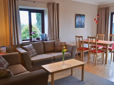 a living room with a couch and a table at Boundary Gallery Cottage in Framlingham