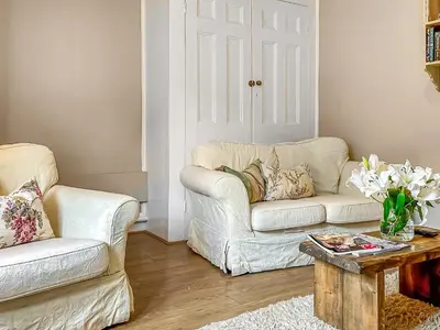 a living room with a couch and a table at Nightingales in Hollesley