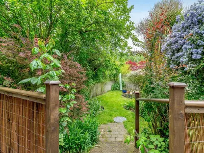 a garden with a wooden fence and a path at Bryanstown Annexe in Woodbridge