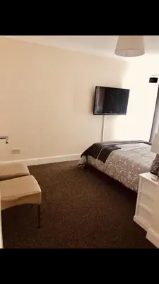 a bedroom with a bed and a tv on the wall at Ac lounge36 Room B in Rochford