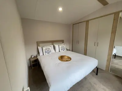 a bedroom with a white bed with a bowl on it at Mersea Retreat in West Mersea