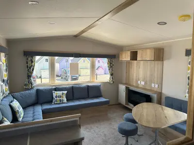 a living room with a blue couch and a table at Mersea Retreat in West Mersea