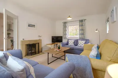 a living room with blue couches and a fireplace at Annie's House in Thorpeness