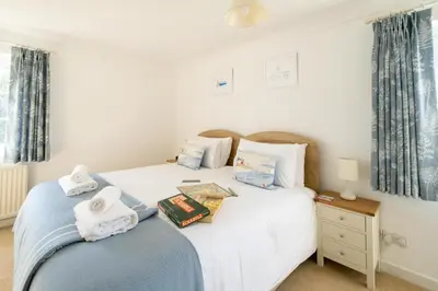 a bedroom with two beds with towels on them at Annie's House in Thorpeness