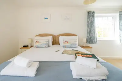 a bedroom with a large white bed with two pillows at Annie's House in Thorpeness