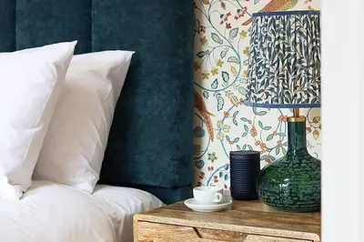 a bedroom with a bed and a table with a lamp at The Pear Tree Inn in Bury Saint Edmunds