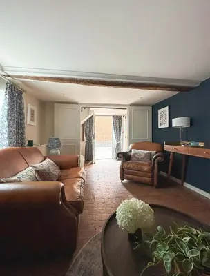 a living room with leather couches and a table at The Pear Tree Inn in Bury Saint Edmunds
