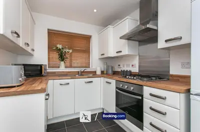 a kitchen with white cabinets and a stove at Stylish House By AR Properties Short Lets & Serviced Accommodation Colchester in Colchester