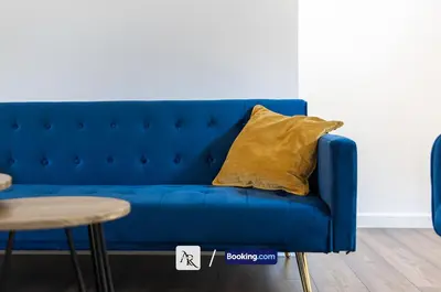a blue couch with a yellow pillow on it at Stylish House By AR Properties Short Lets & Serviced Accommodation Colchester in Colchester