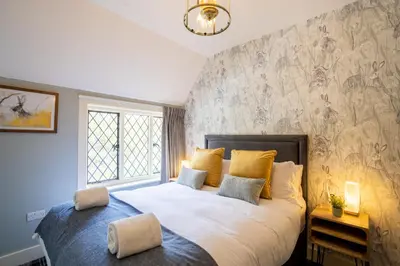 a bedroom with a large bed with yellow pillows at Kettleburgh Chequers in Kettleburgh