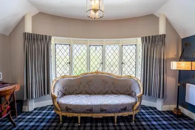 a couch sitting in a room with a window at Kettleburgh Chequers in Kettleburgh