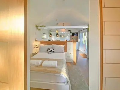 a small bedroom with a bed and a kitchen at The Little Barn in Hoxne