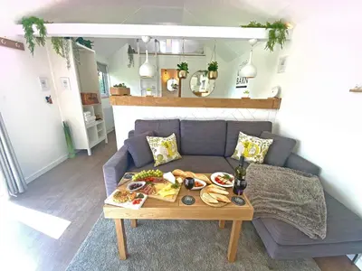 a living room with a table with food on a couch at The Little Barn in Hoxne