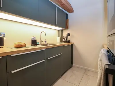 a kitchen with green cabinets and a sink at The Cart Lodge at Grove Barn in Eye