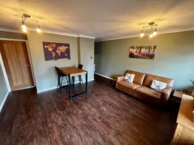 a living room with a couch and a table at Comfy, modern one bed apartment in Leiston