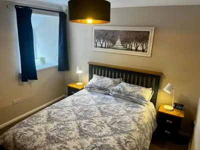 a bedroom with a bed and a window at Comfy, modern one bed apartment in Leiston