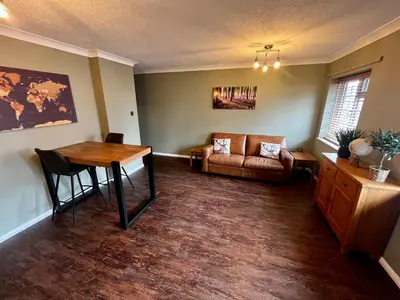 a living room with a table and a couch at Comfy, modern one bed apartment in Leiston