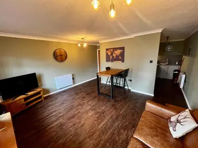 a living room with a table and a couch at Comfy, modern one bed apartment in Leiston