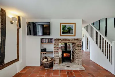 a living room with a brick fireplace and a staircase at 2 Bed in Ilketshall St. Margaret oc-w27520 in Rumburgh