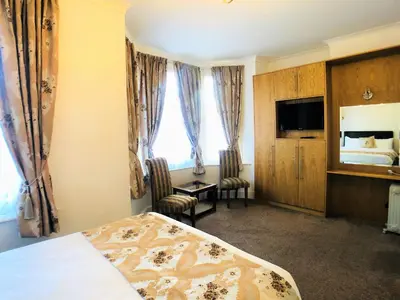 a hotel room with a bed and a television at Ilfracombe House Hotel - near Cliffs Pavilion in Southend-on-Sea