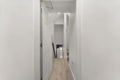 a hallway with white walls and a wooden floor at The Suffolk Gem - Games Room in Ipswich