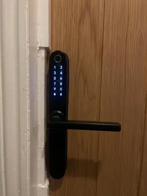 a remote control attached to a wooden door at Cosy entire apartment super king bed near town center in Colchester