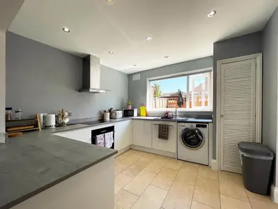 a kitchen with a sink and a washing machine at Grace's Place in Ely in Ely