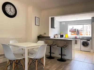 a kitchen with a table and chairs and a clock on the wall at Grace's Place in Ely in Ely