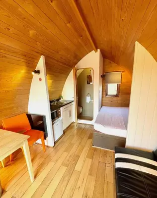 a small room with a bed and a table at MegaPod 3 at Lee Wick Farm Cottages & Glamping in Clacton-on-Sea