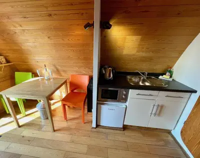 a small kitchen with a table and a sink at MegaPod 3 at Lee Wick Farm Cottages & Glamping in Clacton-on-Sea