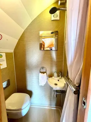 a small bathroom with a toilet and a sink at MegaPod 2 at Lee Wick Farm Cottages & Glamping in Clacton-on-Sea