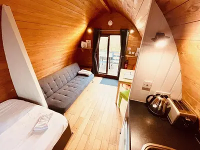 a small room with a bed and a couch at MegaPod 1 at Lee Wick Farm Cottages & Glamping in Clacton-on-Sea