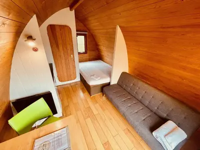an overhead view of a room with a couch and a bed at MegaPod 1 at Lee Wick Farm Cottages & Glamping in Clacton-on-Sea