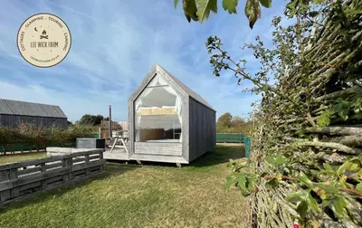 a small grey greenhouse in a yard with grass at Lushna 9 Petite at Lee Wick Farm Cottages & Glamping in Clacton-on-Sea