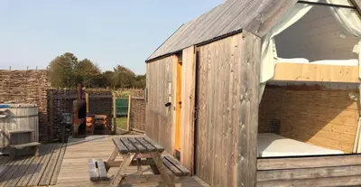 a wooden out house with a bench on a deck at Lushna 2 Petite at Lee Wick Farm Cottages & Glamping in Clacton-on-Sea