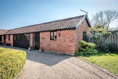 a red brick house with a fence and a driveway at The Studio, Hoo in Woodbridge