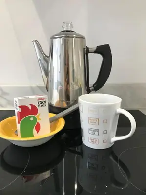 a coffee pot and a plate and a cup on a counter at Dolly Cottage Colchester in Mile End