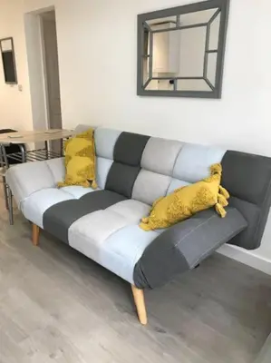 a gray couch with yellow pillows in a living room at Dolly Cottage Colchester in Mile End