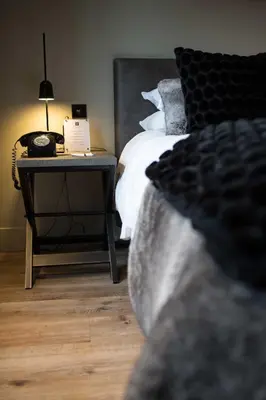 a bedroom with a bed and a table with a phone at Milsoms in Dedham